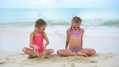 可爱的女孩玩沙子海滩孩子们坐着浅水使沙子城堡